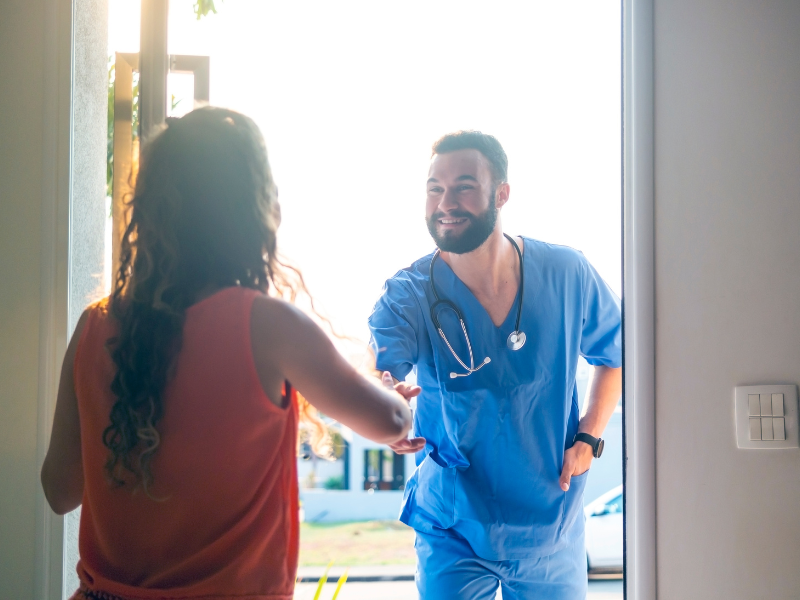 A nurse visits a patient at home.