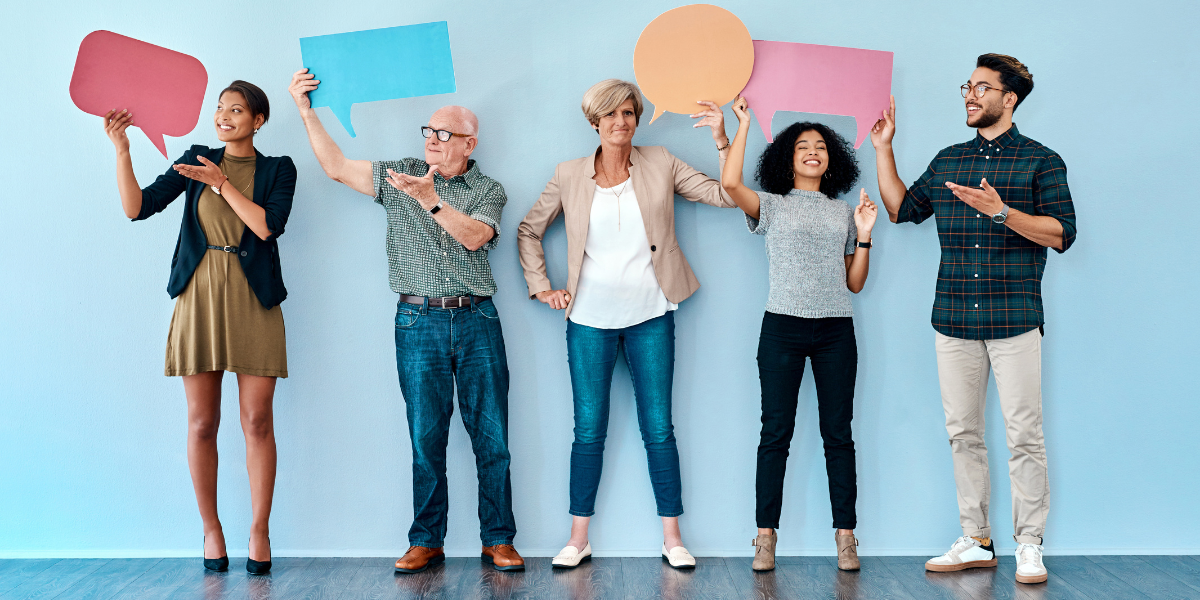 A wide range of peopled hold up signs shaped like speech bubbles. 